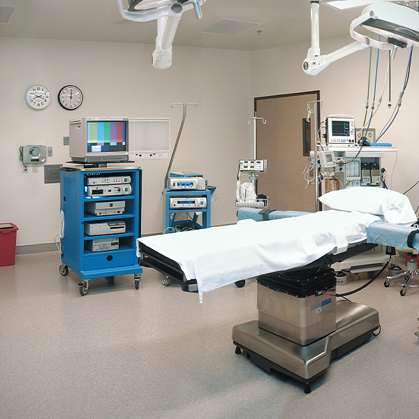 A fully equipped hospital operating room with a surgical table, monitors, and medical equipment.
